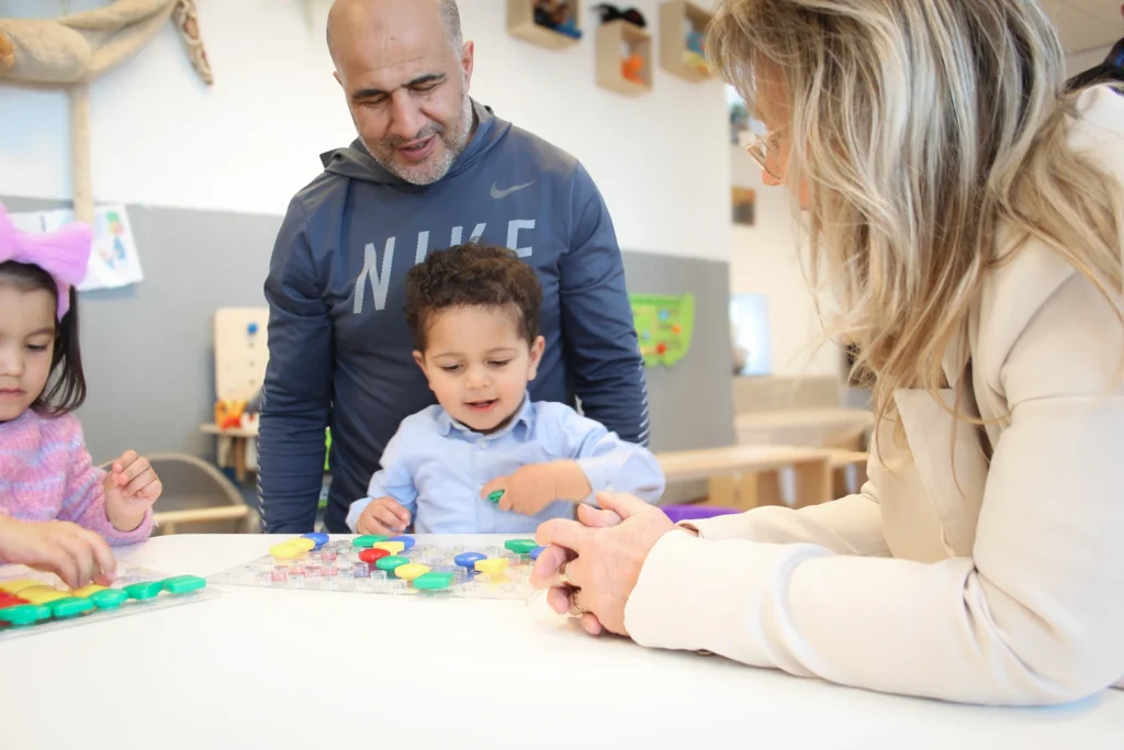 Kind speelt met puzzel samen met volwassenen in kinderopvang Culemborg